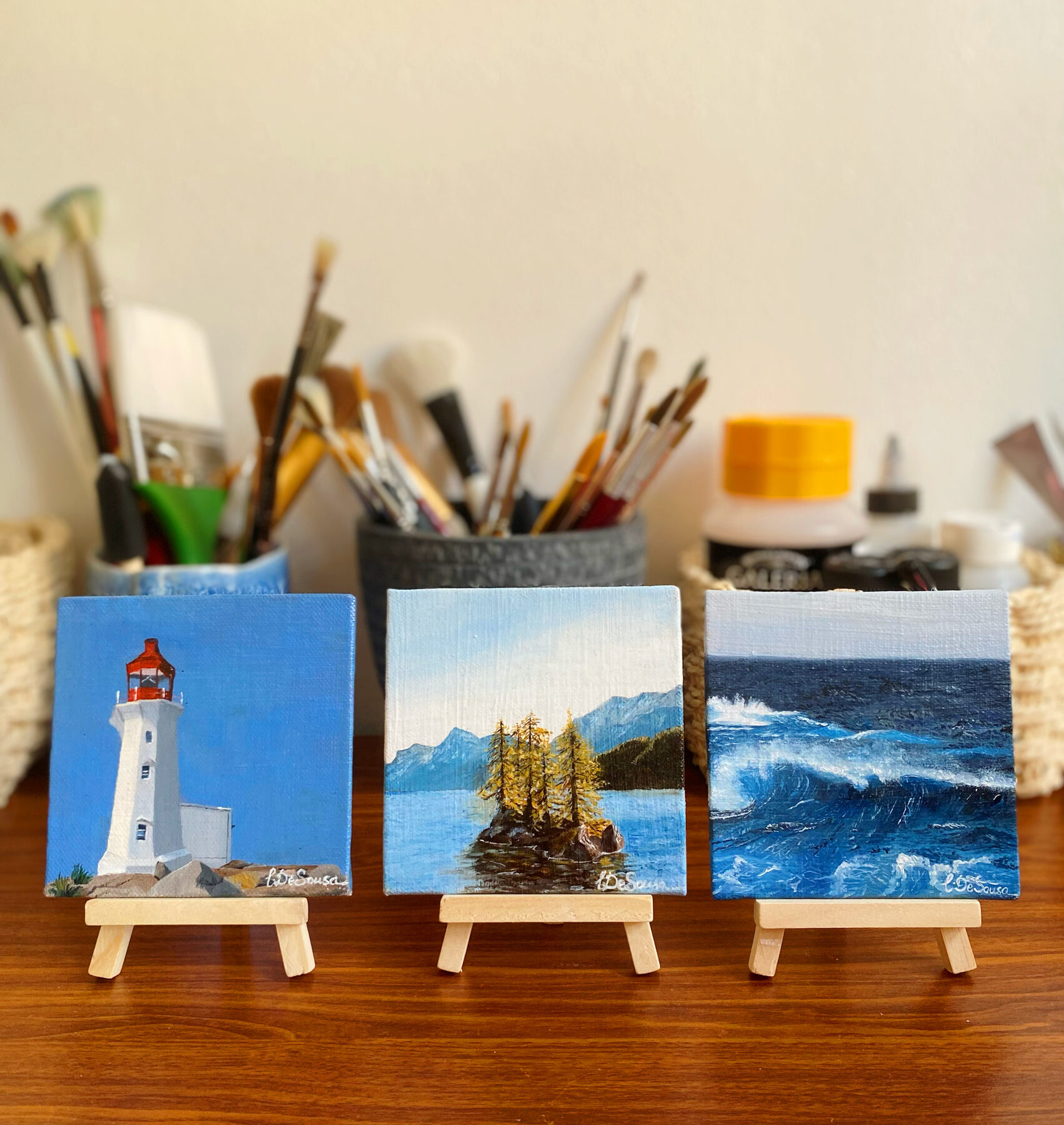 Three miniature paintings on easels in studio